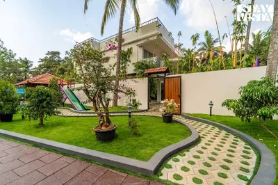 a house with a garden and a playground at StayVista at Lagoons Kuruva with Shared Pool, Lawn in Chekadi