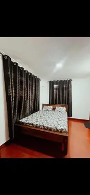 a bed in a room with black curtains at Coffee land in Kaniyāmbetta