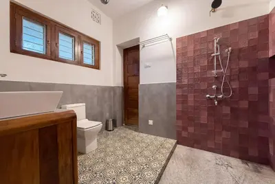 a bathroom with a shower and a toilet and a sink at Himalaya - 6bh Bunglow in Mysore