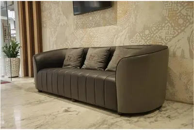 a leather couch in a room with a wall at Kanak Residency in Green Island