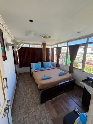 a bedroom with a bed with blue pillows in it at DM&sons in Coonoor