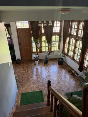 a large room with a staircase and windows at DM&sons in Coonoor