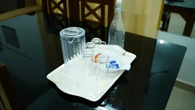 a table with glasses and a bottle on it at Stay Ease Rental Rooms in Palakkad