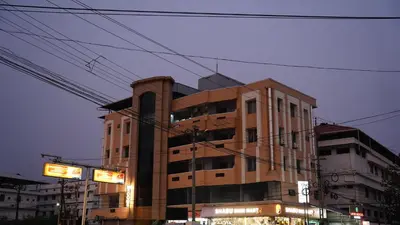 a tall building with some signs in front of it at Stay Ease Rental Rooms in Palakkad