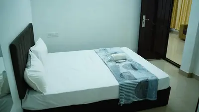 a bed with white sheets and towels on it at Stay Ease Rental Rooms in Palakkad