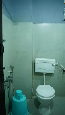 a bathroom with a white toilet in a room at Stay Ease Rental Rooms in Palakkad