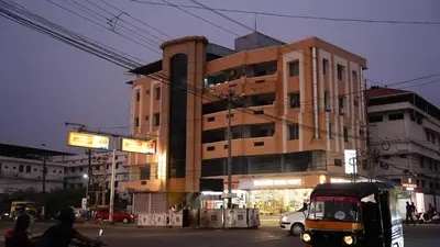 a large building on a city street at night at Stay Ease Rental Rooms in Palakkad