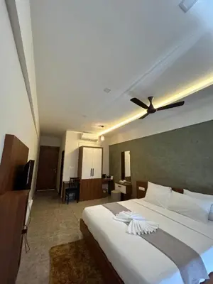 a bedroom with a large bed with a ceiling fan at Dream wagon hotel lakkidi in Vythiri