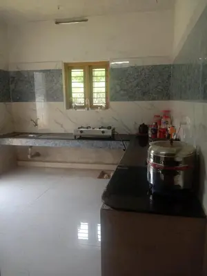 a kitchen with a stove and a counter top at Kalpanahomestay in Vattavada