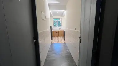 a hallway leading to a bathroom with a sink at Jo Homes in Alwaye