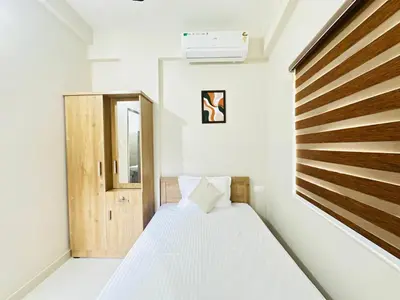 a small bedroom with a bed and a window at Nila Inn Calicut Near Hilite Mall in Kozhikode