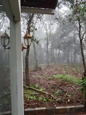 a porch with a foggy yard with a street light at Skygarden Resort Vythiri in Vythiri