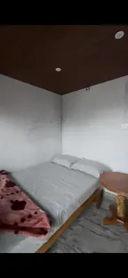 a bedroom with a bed and a table in it at Park view homestays in Vālpārai