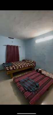 a room with two beds and a rug on the floor at Park view homestays in Vālpārai