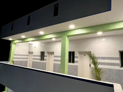 a bathroom with a row of stalls with green lights at Hotel ZB comforts MYSORE in Mysore