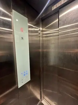 a metal elevator with a sign on the side of it at Dakshima Residency in Mysore