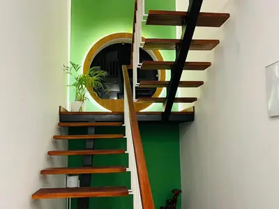 a spiral staircase in a room with a green wall at Mistora Stays 2BHK Private villa in Kalpetta