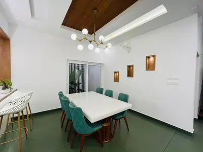 a dining room with a white table and chairs at Mistora Stays 2BHK Private villa in Kalpetta