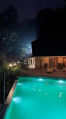 a swimming pool lit up at night at WyldWater Retreat in Vythiri