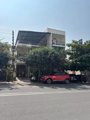 a red car parked in front of a building at Āsare attic in Mysore