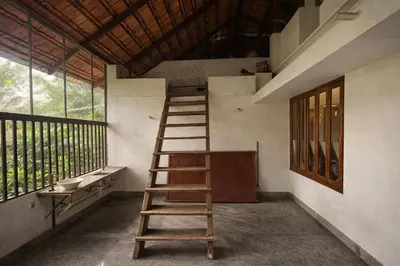 a wooden ladder in a room with a window at Heritage Home in Ernakulam North Paravur in Ernakulam