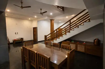 a dining room with a table and a staircase at Heritage Home in Ernakulam North Paravur in Ernakulam