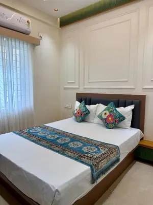 a bedroom with a bed with two pillows at The Grand Sarayu in Mysore