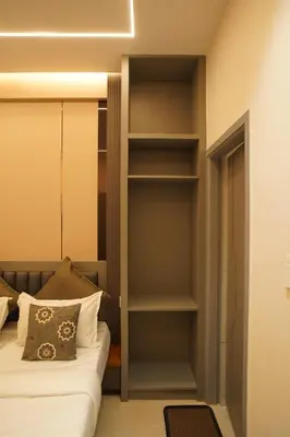 a bedroom with a bed and a book shelf at The Grand Sarayu in Mysore