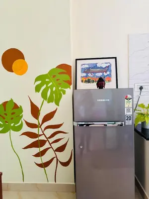 a refrigerator in a room with a wall at Aasare Attic 2 in Mysore