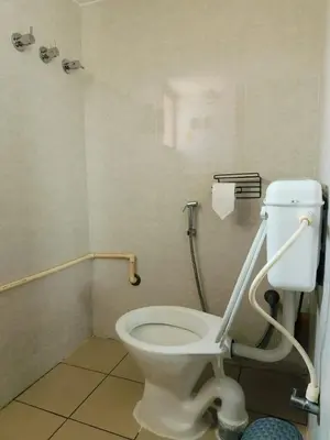 a bathroom with a white toilet with a handicapptionptionptionption at Aasare Attic 2 in Mysore