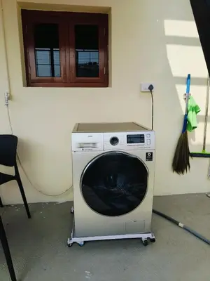 a washing machine with a broom on top of it at Aasare Attic 2 in Mysore