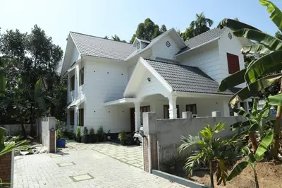 a white house with a fence in front of it at Brand new 4 BHK luxury villa near kochi airport in Nedumbassery