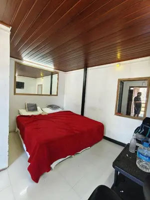 a bedroom with a red bed and a mirror at KINGS Home Stay in Ooty