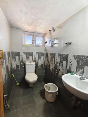 a bathroom with a toilet and a sink at KINGS Home Stay in Ooty