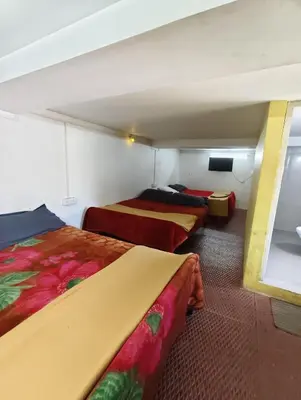 a room with two beds and a tv in it at KINGS Home Stay in Ooty