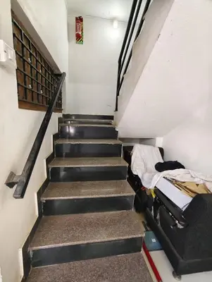 a stair case with a bed and a couch at KINGS Home Stay in Ooty