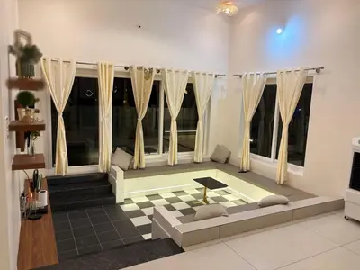 a living room with a couch and some windows at Sunset Villa Dusk looks better from here in Mysore