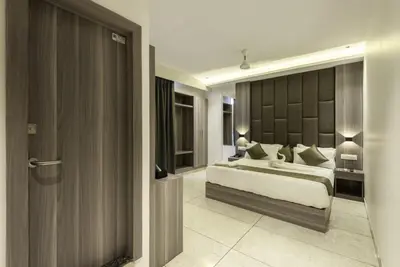 a bedroom with a king sized bed in a room at Hotel Hycon in Kozhikode