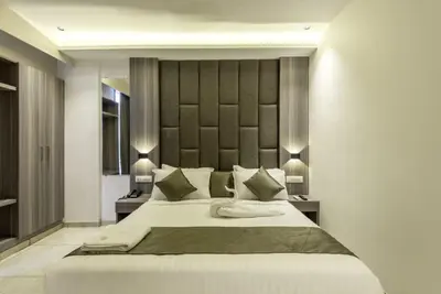 a bedroom with a large bed with two night stands at Hotel Hycon in Kozhikode