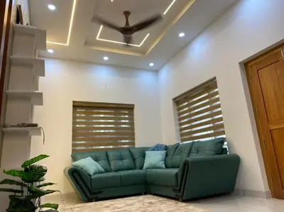 a living room with a green couch and a ceiling at Izzath Villa in Kottakkal
