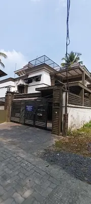 a house with wooden garage doors in front of it at Majestic Mirage Service Villa in Kalpetta