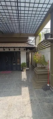 a building with awning and potted plants on a patio at Majestic Mirage Service Villa in Kalpetta