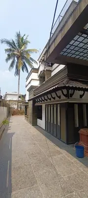 a building with a palm tree in front of it at Majestic Mirage Service Villa in Kalpetta