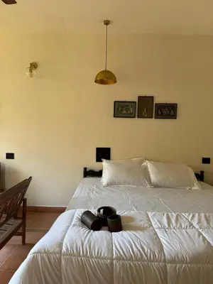 a bedroom with a large white bed with two bowls on it at Homestay in Alappura 3 Cottage Farmstay by Homeyhuts in Tattamangalam