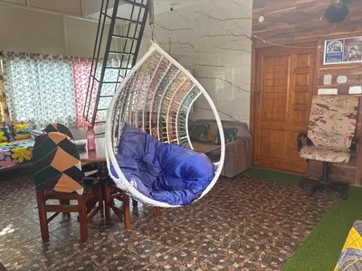 a hanging chair with a blue pillow in a room at 4 Beds 6 People stay Calm, Comfortable Place in Mysore