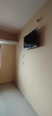 a room with a tv on the wall at sarathihomestay in Vālpārai