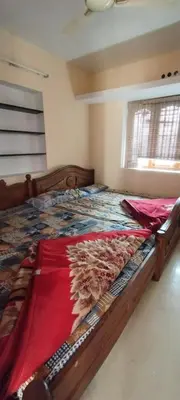 a bedroom with a large wooden bed in a room at sarathihomestay in Vālpārai