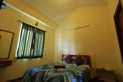 a bedroom with a bed and a window at Hill Side Cottage in Ooty