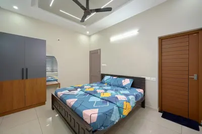 a bedroom with a bed and a wooden closet at 4-Bedroom Villa near CIAL Airport 25 Min Drive ! in Alwaye