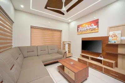 a living room with a couch and a flat screen tv at 4-Bedroom Villa near CIAL Airport 25 Min Drive ! in Alwaye